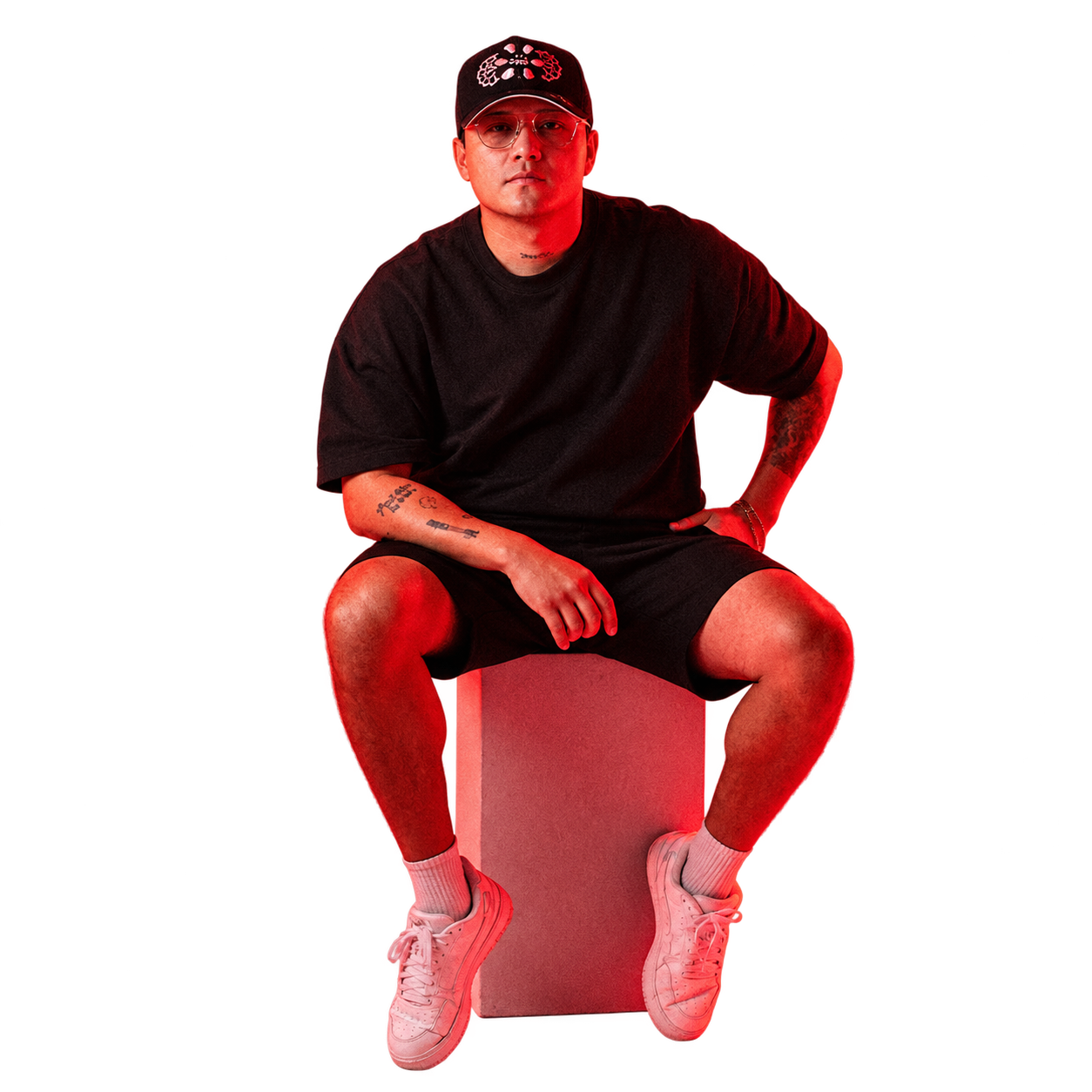 Gerardo Rocca sentado de frente, con gorra y lentes, bajo la iluminación roja de su fotografía original